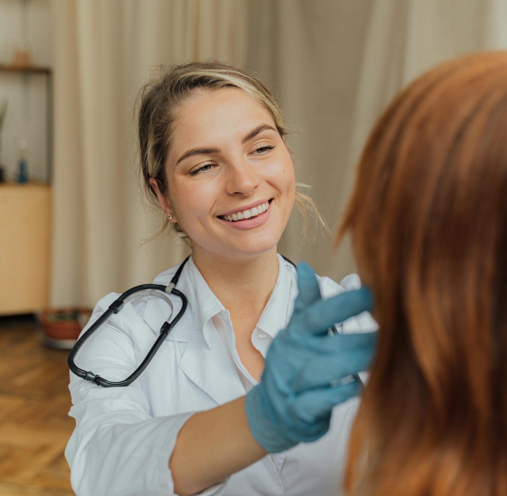 A cheerful healthcare professional examining a patient indoors, promoting positive healthcare experiences.